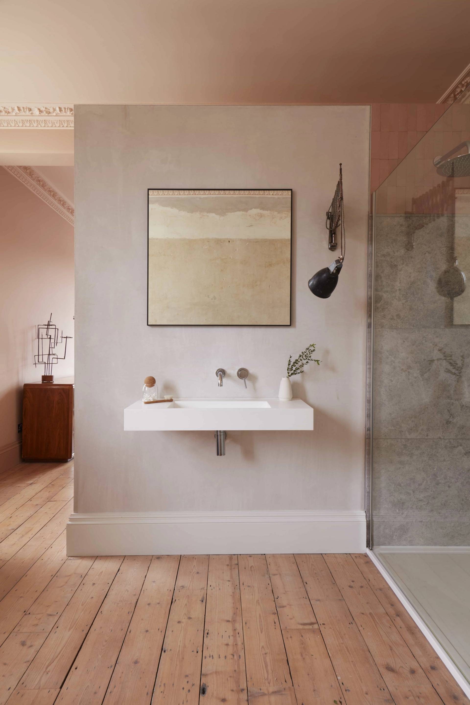 Sleek plaster bathroom vanity featuring a floating white sink, brass taps, and micro-cement walls, ideal for beauty brand shoots, Love Locations TN34.
