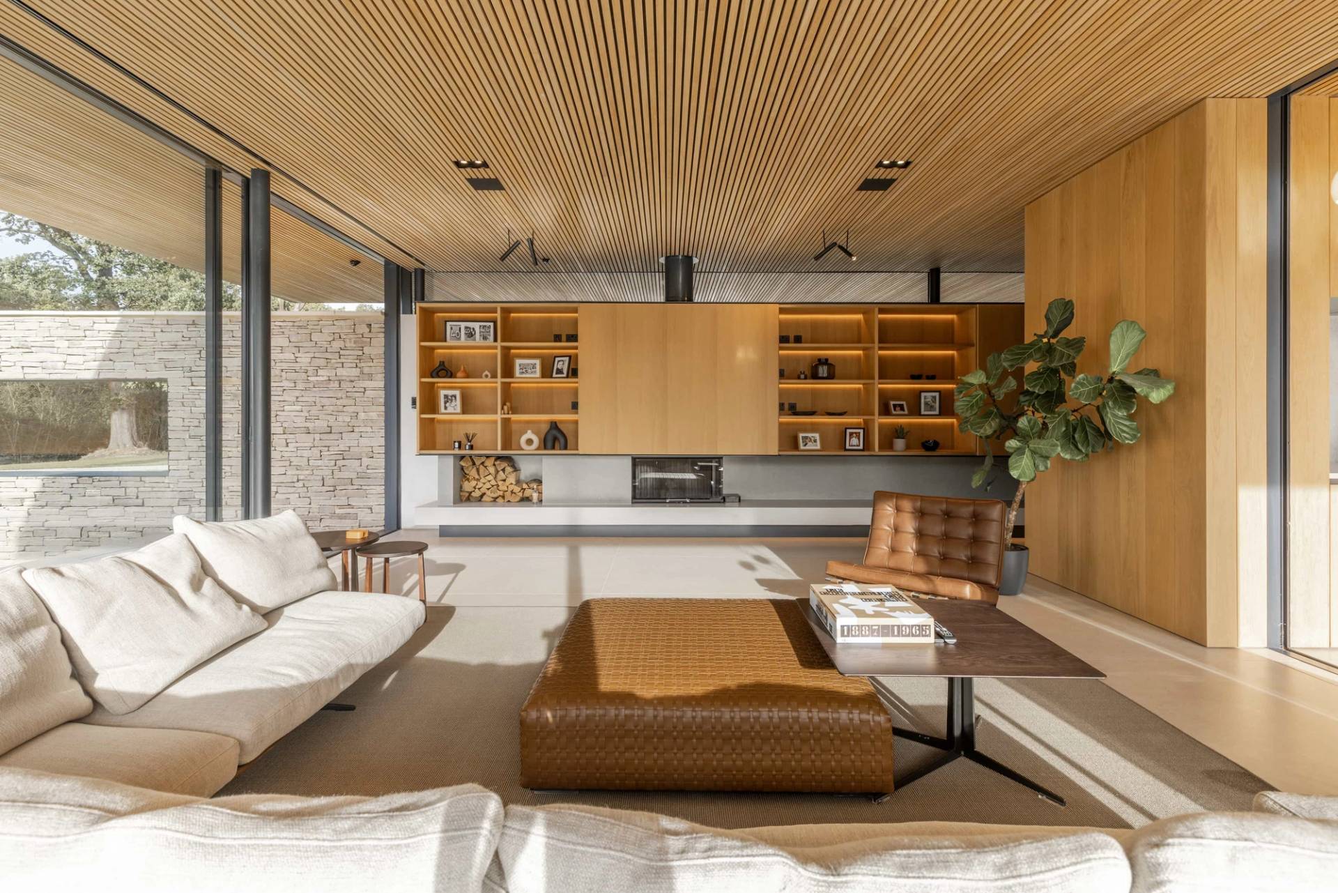 Contemporary open-plan living room interior in Essex, CM4 showcasing minimalist low-profile furniture, natural wood finishes, and integrated shelving, Love Locations.