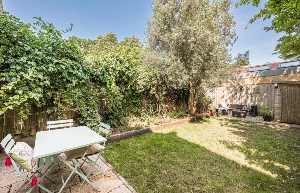 Outdoor garden patio dining space with a white metal bistro table and chairs for summer lifestyle campaigns, Love Locations.