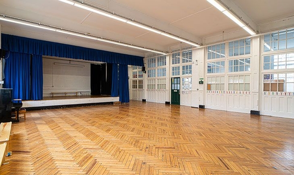 Spacious institutional hall space with traditional parquet flooring for commercial video shoots in North London, through Love Locations.