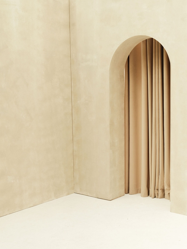 Event venue featuring a brushed plaster arched wall and flowing curtain at Love Locations Brixton Warehouse.