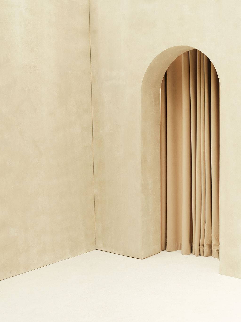 Event venue featuring a brushed plaster arched wall and flowing curtain at Love Locations Brixton Warehouse.