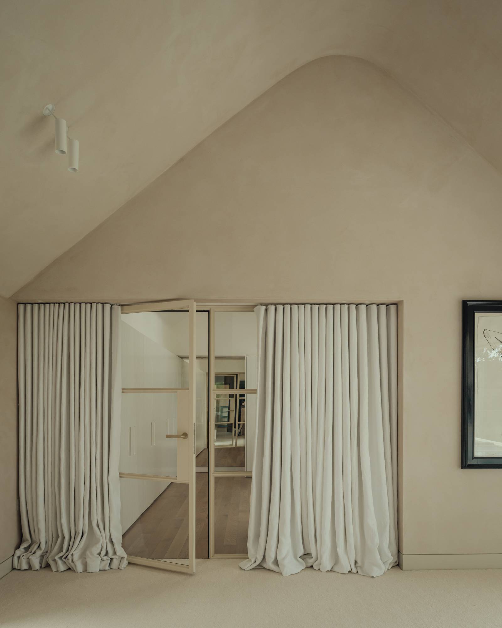 Minimalist bedroom layout with vaulted ceilings, neutral curtains, and framed wall art, suitable for home decor lookbooks, Love Locations.