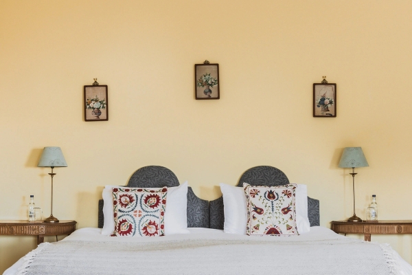 Yellow bedroom suite featuring a four-poster canopy bed, embroidered pillows, and period lamps, Love Locations KY15.