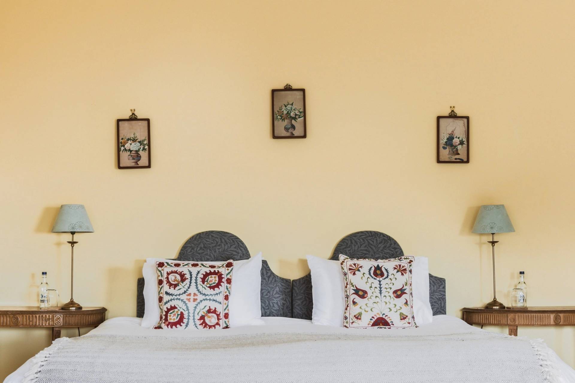 Yellow bedroom suite featuring a four-poster canopy bed, embroidered pillows, and period lamps, Love Locations KY15.