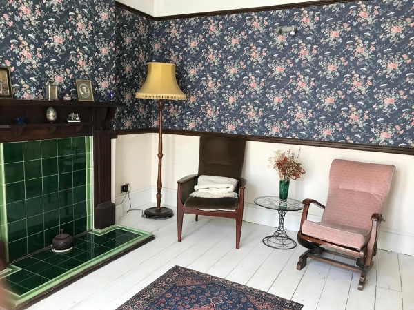 Character lounge featuring an original tiled fireplace hearth, period wall panelling, and classic mid-century furnishings, ideal for moody storytelling photography, Love Locations SE25.