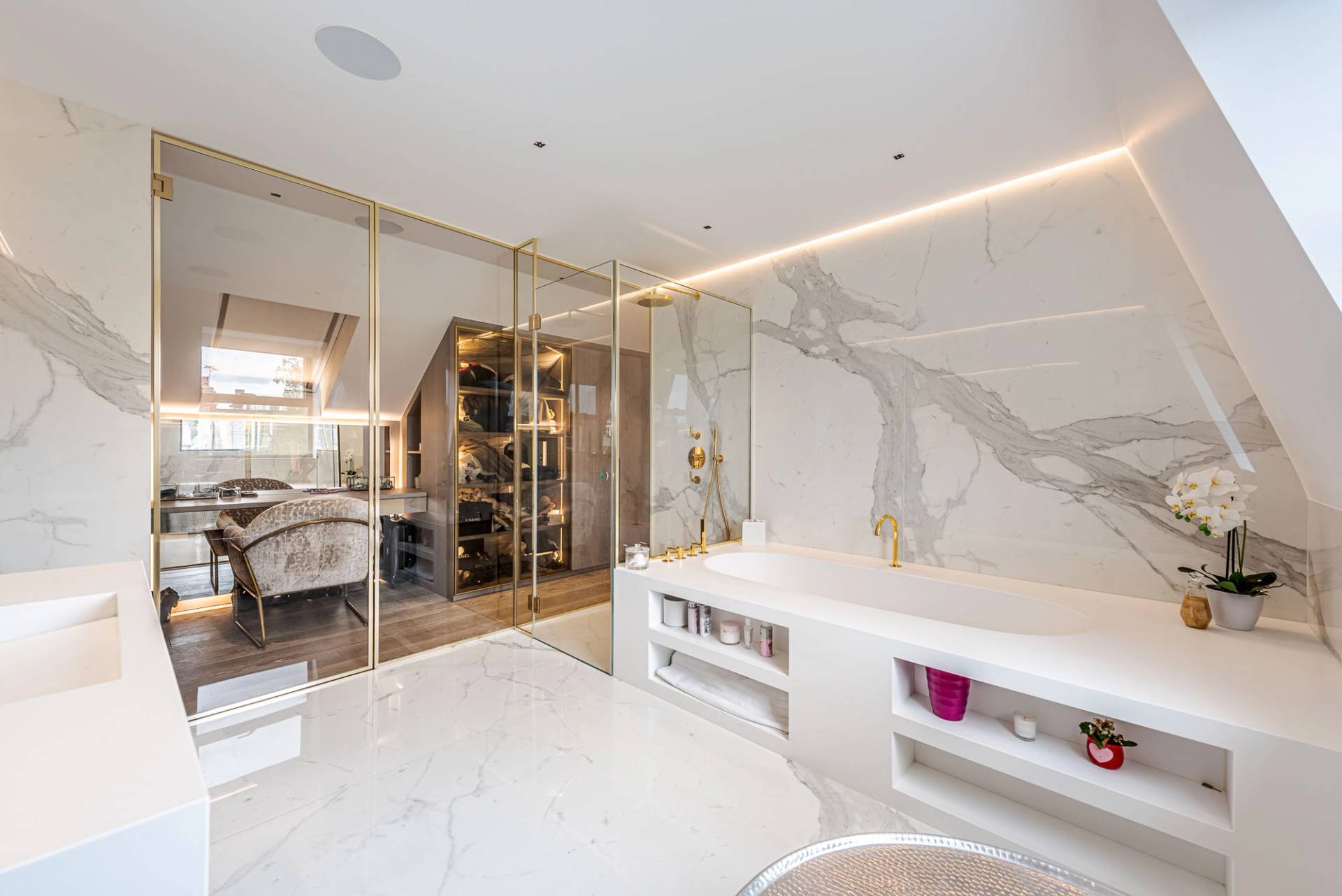 Master ensuite bathroom with a freestanding white soaking tub, marble walls, and glass shower, Love Locations SW11.