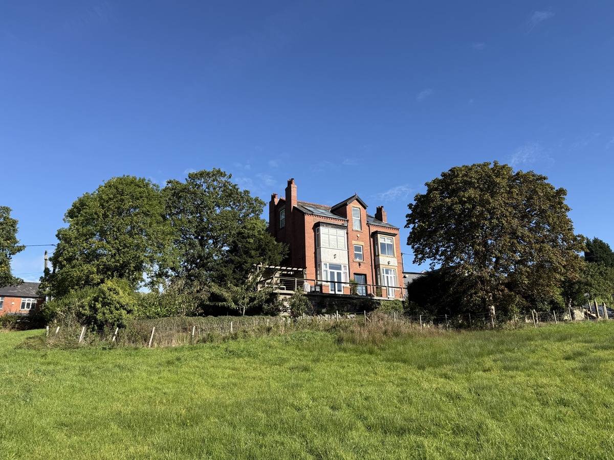 Sweeping view across a vast green paddock and private grounds belonging to a film location in Stockport SK6 via Love Locations.