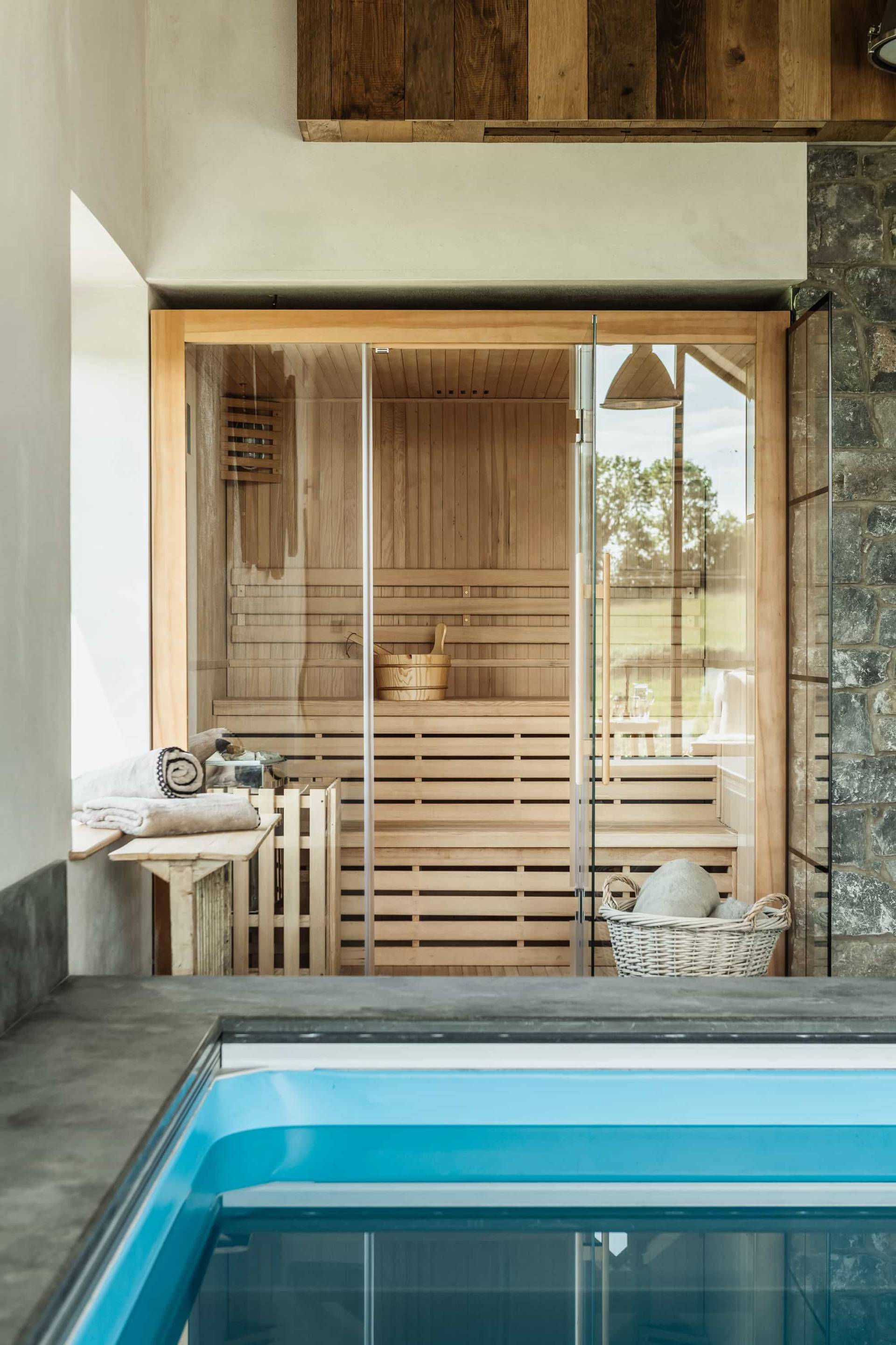 Poolside sauna room shoot location in Castleblayney County Monaghan Ireland by Love Locations, featuring glass doors and timber slatted seating next to the pool.