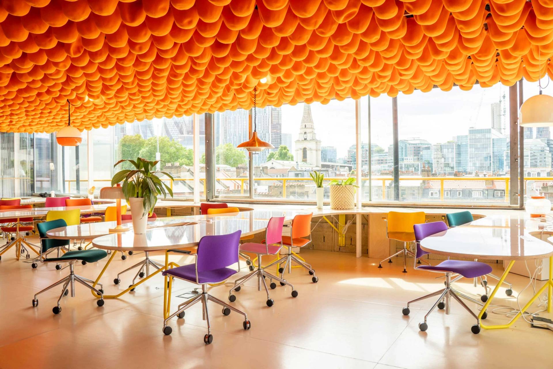 Modern open plan workspace with distinctive yellow ceiling and collaborative seating in Whitechapel London – love locations