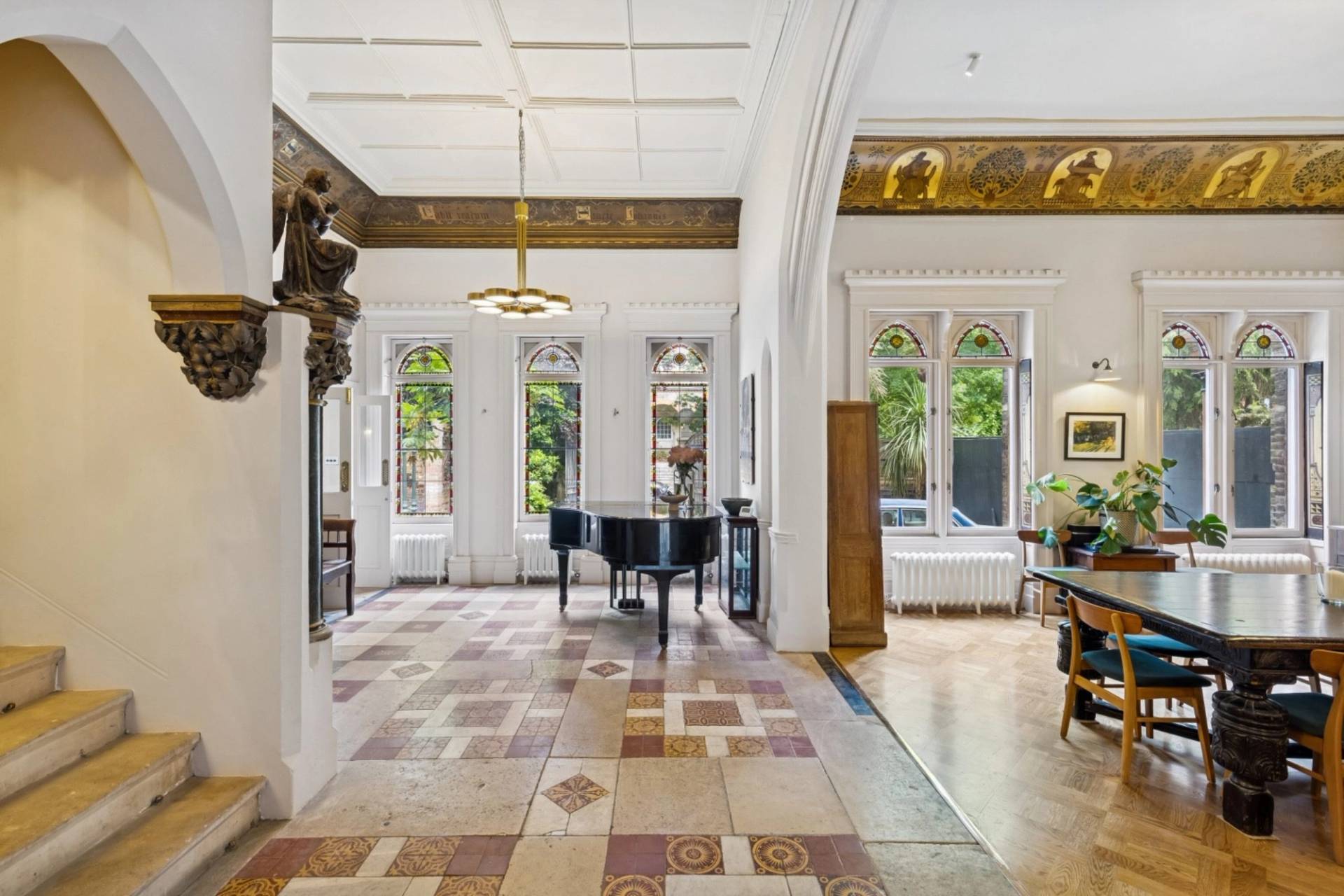 Bright grand hall shoot location with patterned tiled flooring and grand piano in a gothic home in Hampstead NW3 available through Love Locations.