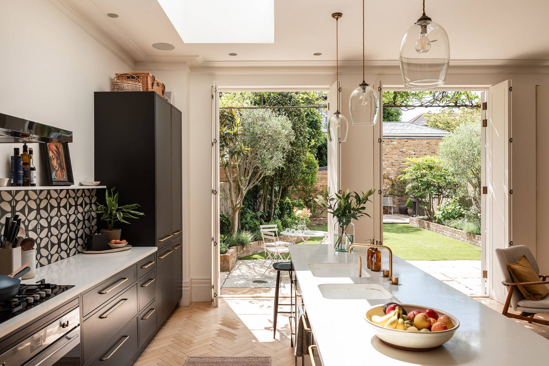 Open kitchen island view looking out through tall French doors into a private landscaped garden, perfect for outdoor-indoor lifestyle filming, Love Locations.