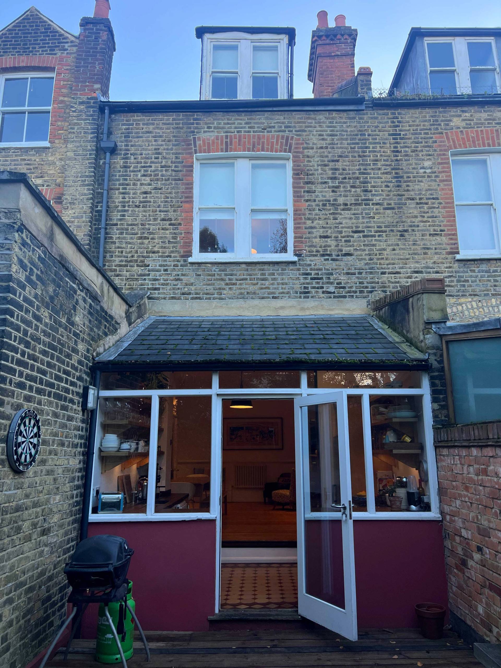 Rear exterior view of a Victorian brick property with a conservatory extension opening onto garden grounds, Love Locations SE5.
