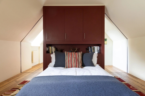 Love Locations unique attic bedroom shoot space Steyning: Cosy loft bedroom built into a statement plum-colored custom wardrobe surround, great for unique lifestyle branding.