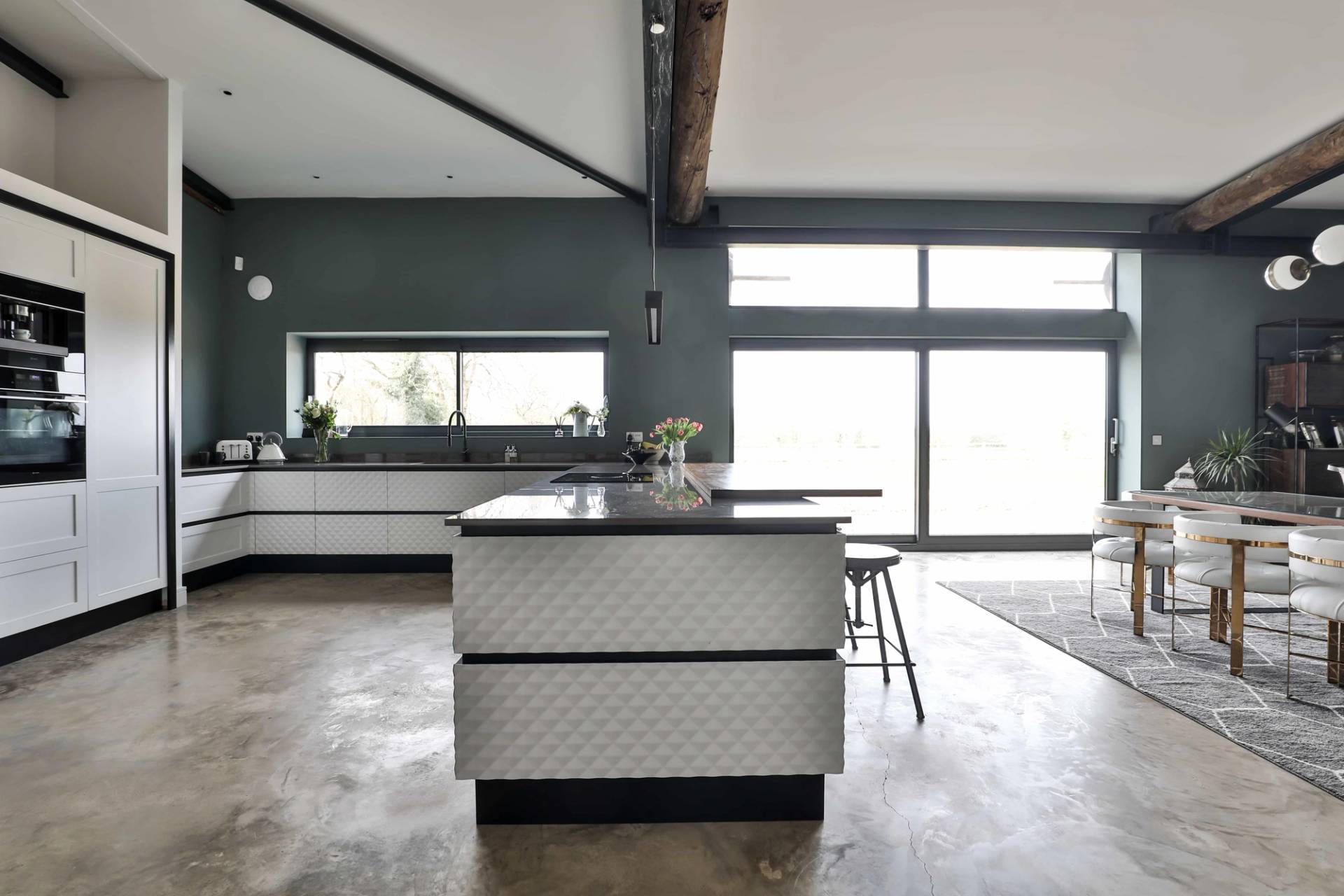 Kitchen island unit set in front of floor-to-ceiling glass sliding doors with scenic countryside views, Love Locations CV23.