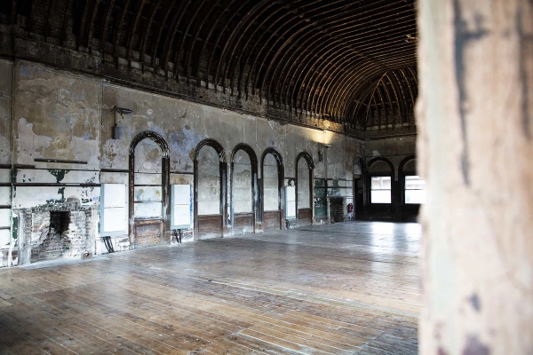 Atmospheric abandoned billiards hall featuring distressed walls and tall windows, a unique South East London location for fashion shoots and exhibitions.