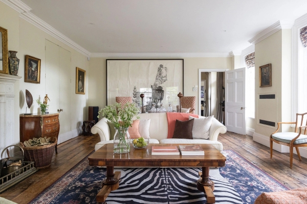 Love Locations traditional country house shoot location Steyning BN44: Grand Georgian drawing room featuring white sofas, a rustic wood coffee table, zebra print rug, and open fireplace, ideal for period dramas and luxury brand shoots.