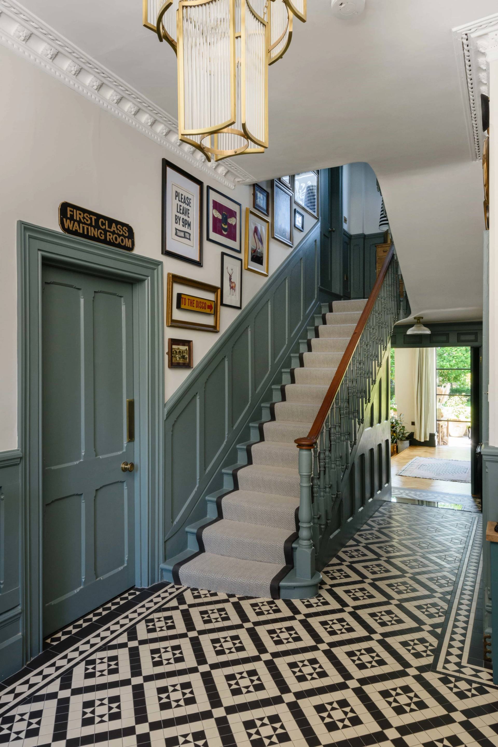 Grand entrance hall featuring grey wall panelling, geometric black and white floor tiles, and carpeted staircase, Love Locations TW11.
