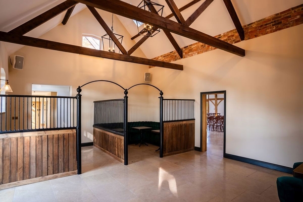 Unique luxury stable block interior with dark wood partitions, perfect as a TV drama or commercial filming location via Love Locations.