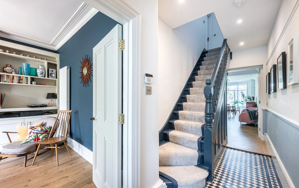 Edwardian entrance hallway location house featuring traditional black and white checkerboard floor tiles and a carpeted staircase, Love Locations.