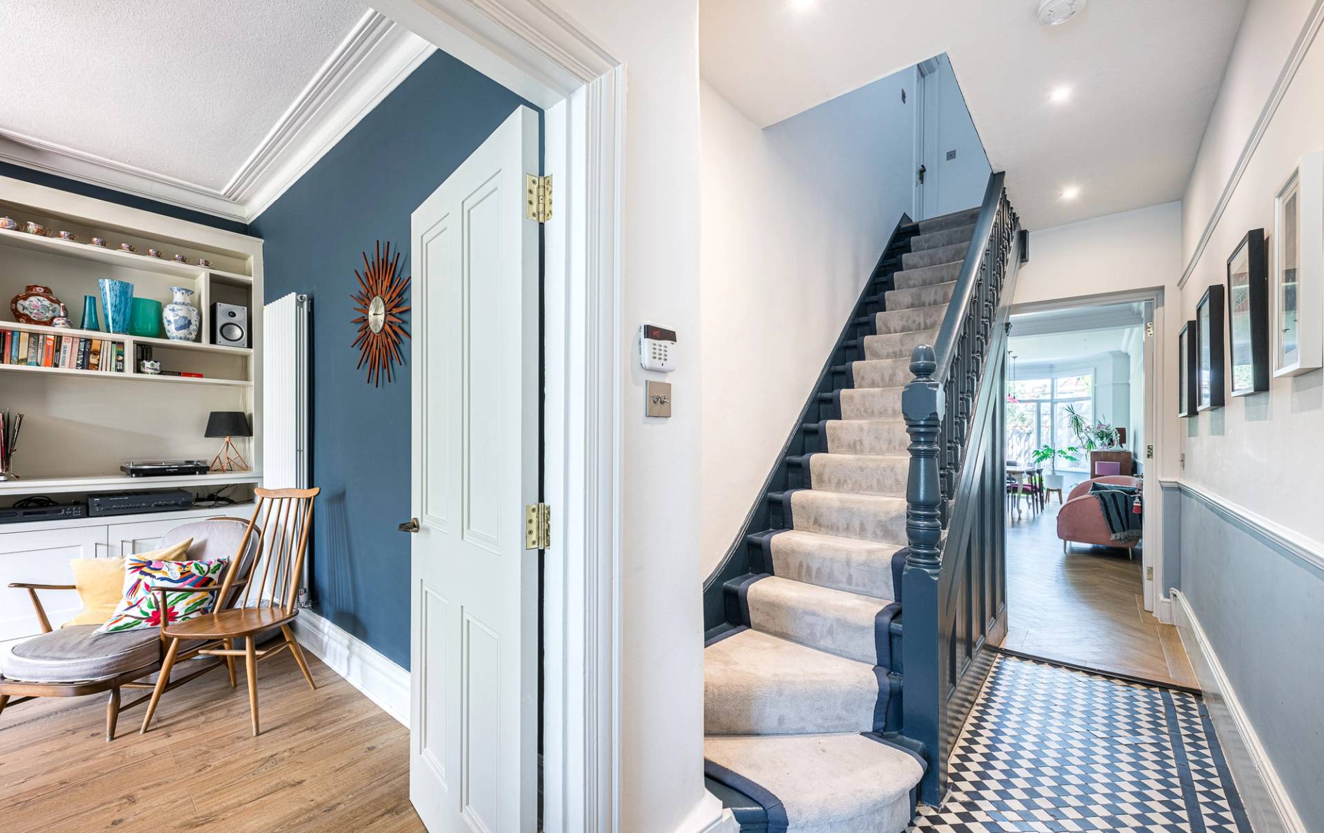 Edwardian entrance hallway location house featuring traditional black and white checkerboard floor tiles and a carpeted staircase, Love Locations.