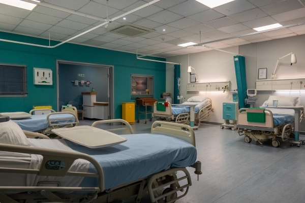 Hospital ward bay with medical beds and wall-mounted patient monitoring units, Love Locations UB4.