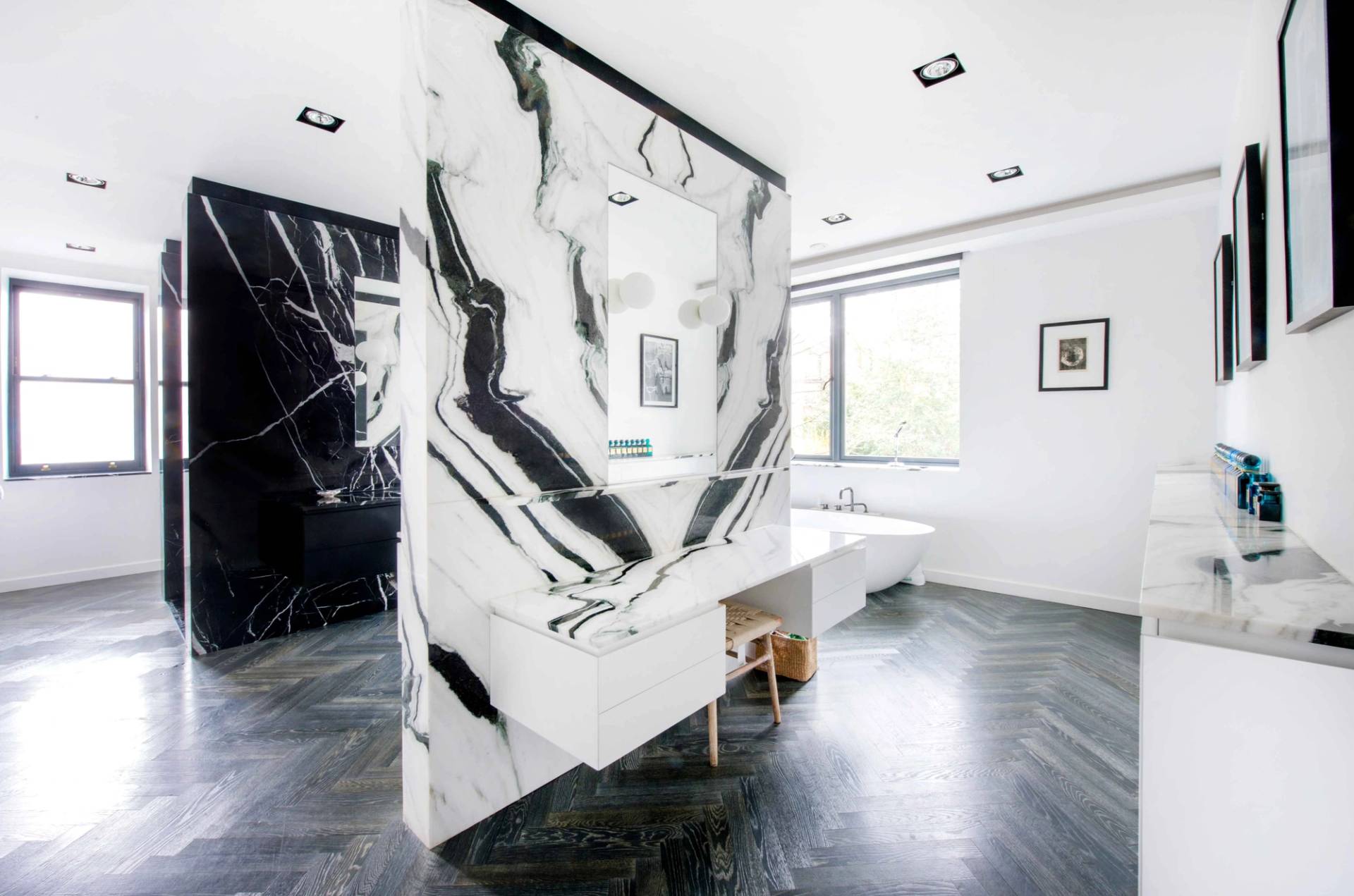 Bespoke master ensuite bathroom showcasing dramatic book-matched marble cladding, freestanding bathtub, and modern brass fixtures, Love Locations NW3.