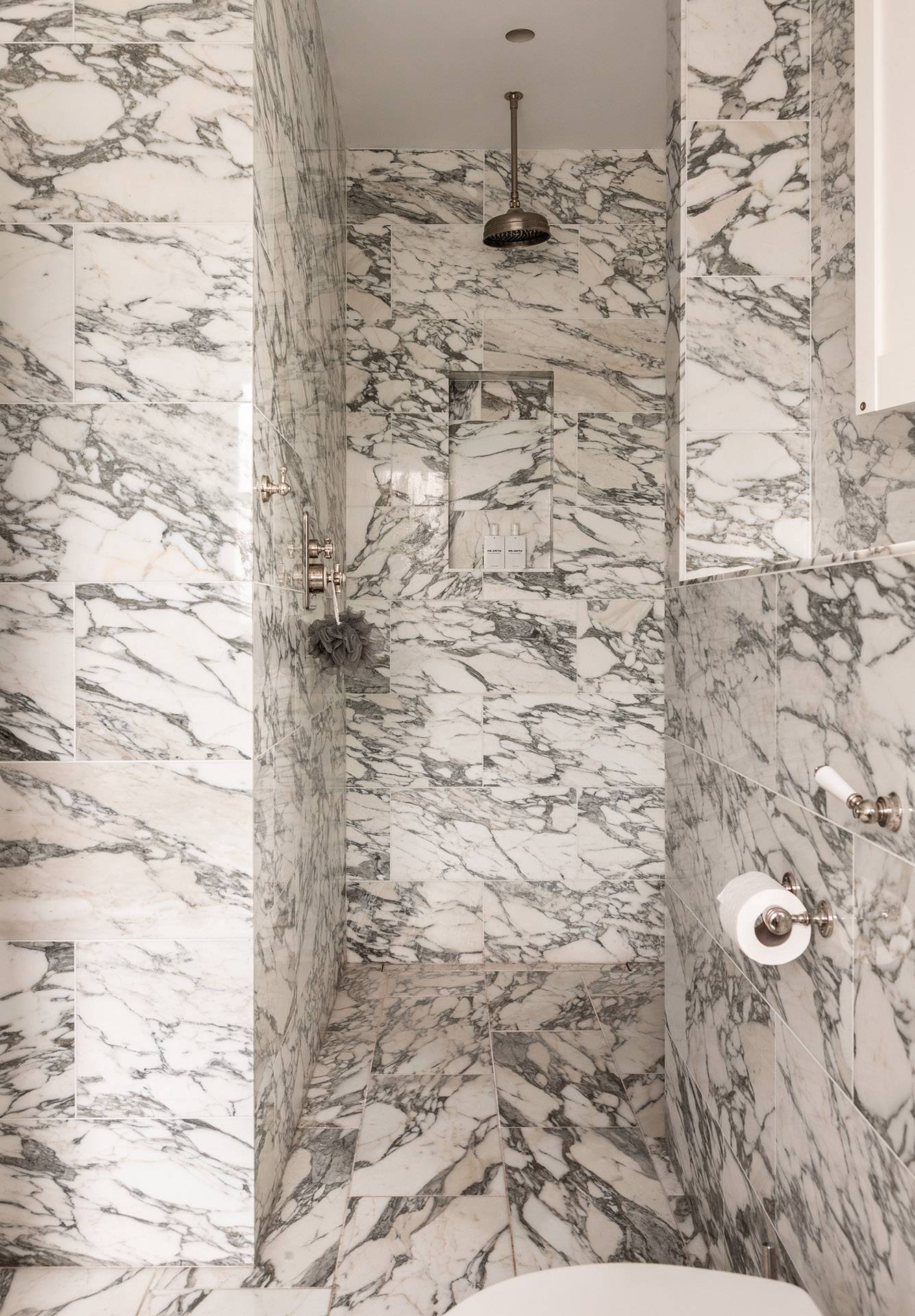 Spacious marble walk-in shower enclosure with intricate grey veining details, Love Locations TW1.