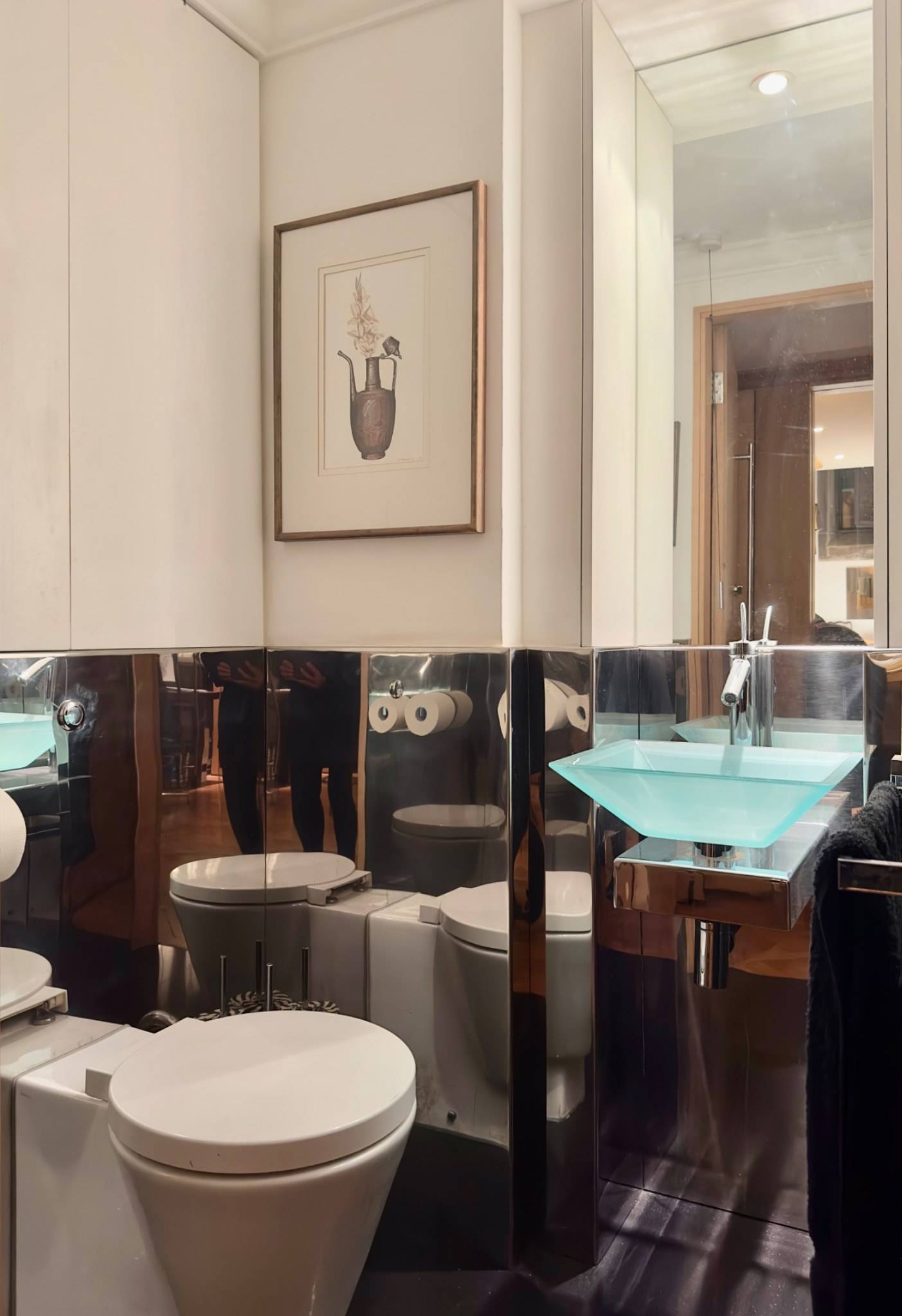 Contemporary bathroom featuring dark tiled lower walls, mirror reflection, and modern glass sink basin in Oval SE5 from Love Locations.