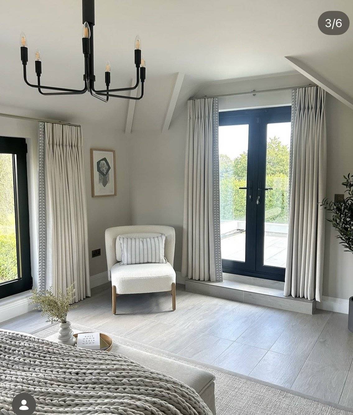 Airy neutral bedroom location property in Essex CM4 via Love Locations, with full-length windows, soft grey curtains, a white accent armchair, and light wood flooring.