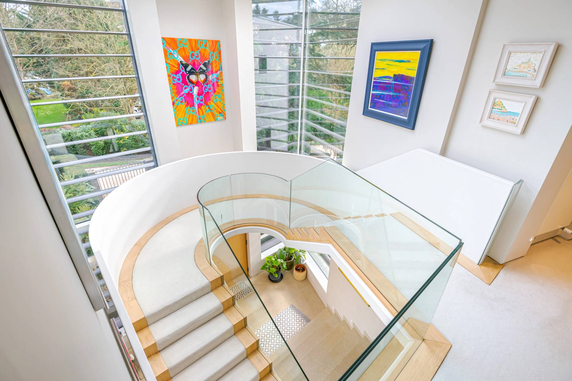High-angle view down a curved floating staircase with glass balustrades and light timber treads, ideal for fashion shoot transitions, Love Locations KT2.