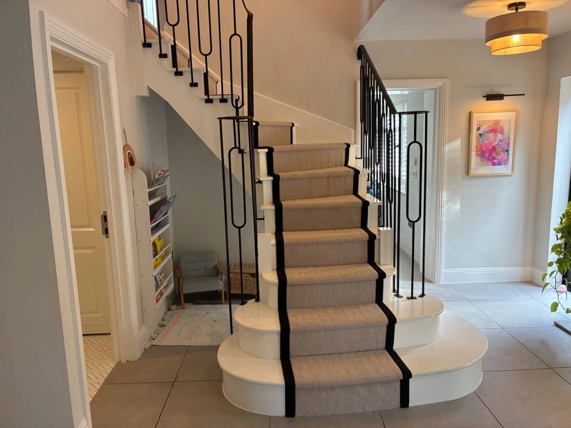 Grand feature staircase with custom wrought iron balustrades and carpet runner inside an Essex CM4 production property from Love Locations.