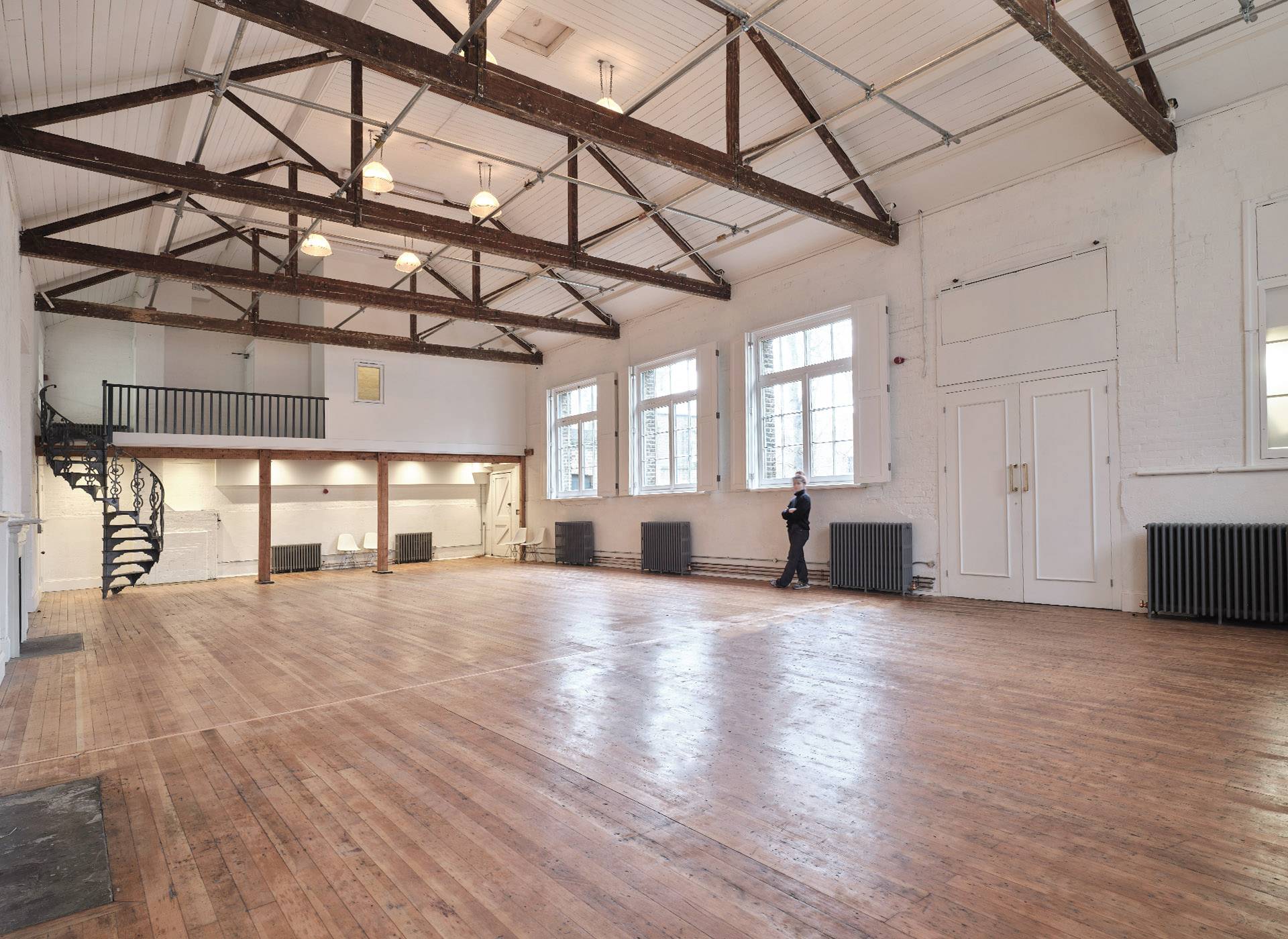 Grand event hall venue with large multi-pane windows, industrial lighting, and wooden floors in Shoreditch, E2, perfect for corporate video production, Love Locations.