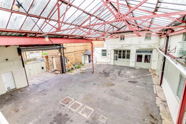 High-angle view of an expansive covered industrial yard venue, perfect for production setups, Love Locations London.