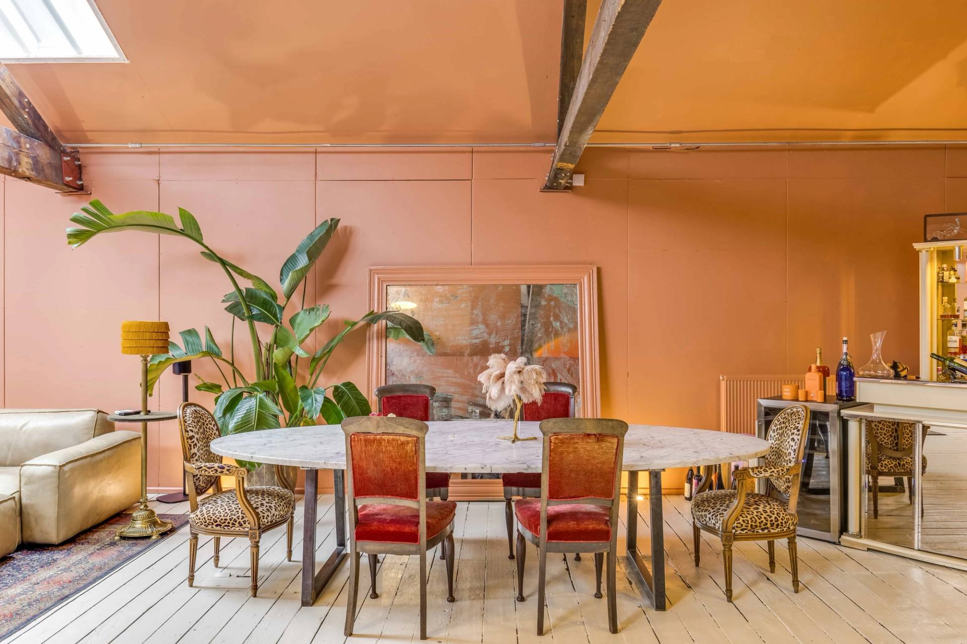 Stylized dinner party setting with a marble dining table and rich red velvet chairs, ideal for editorial media, Love Locations.