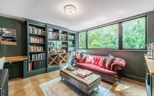 Cosy snug room shoot space with built-in bookshelves, parquet flooring, and a classic red leather Chesterfield sofa, Love Locations.