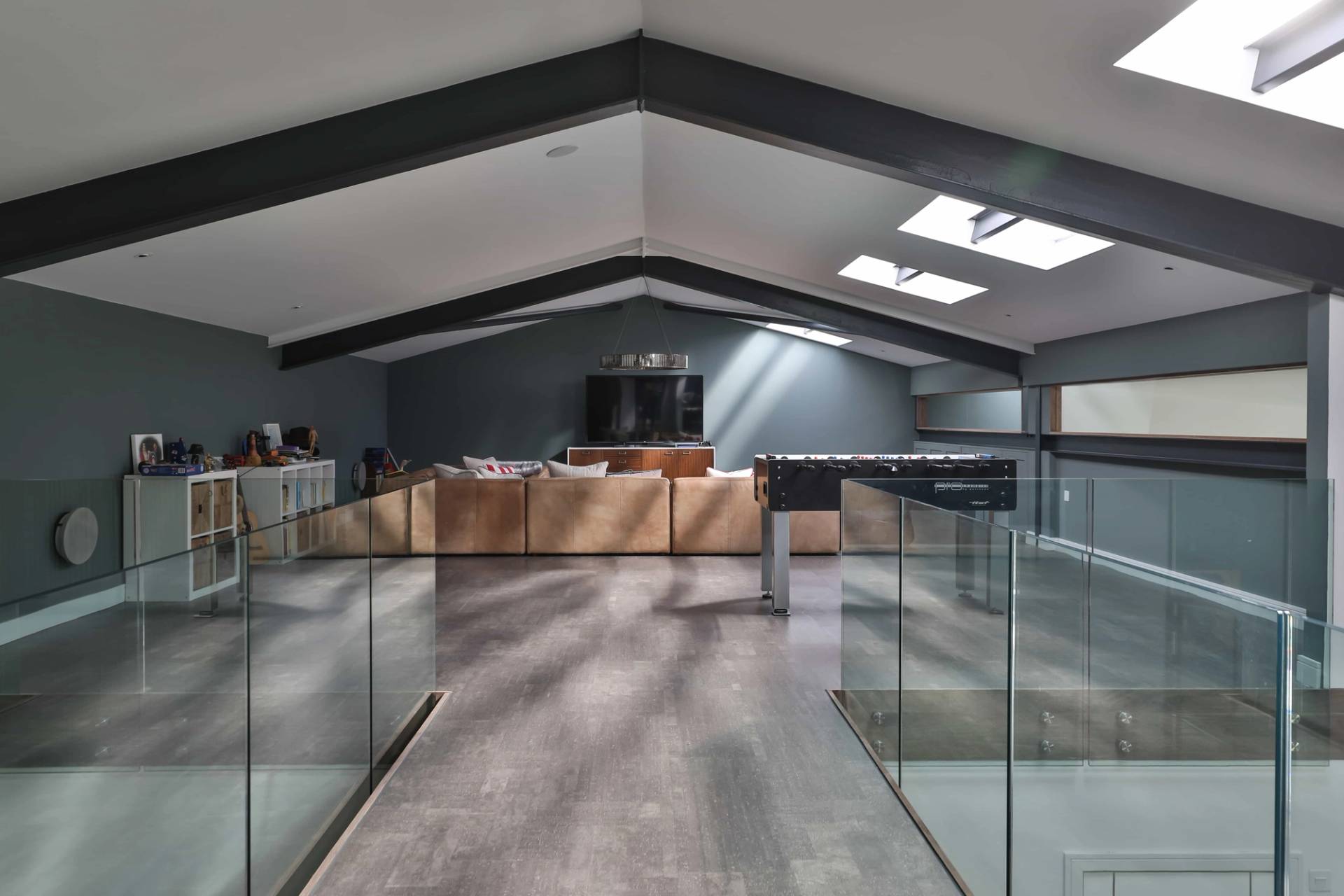 Mezzanine gallery perspective looking past glass railings across a spacious open-plan barn layout, Love Locations CV23.