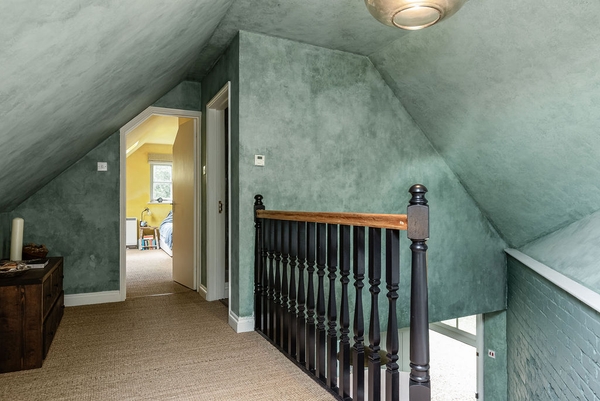 First-floor landing with painted walls and traditional staircase at Love Locations house in Liss, Hampshire GU33.