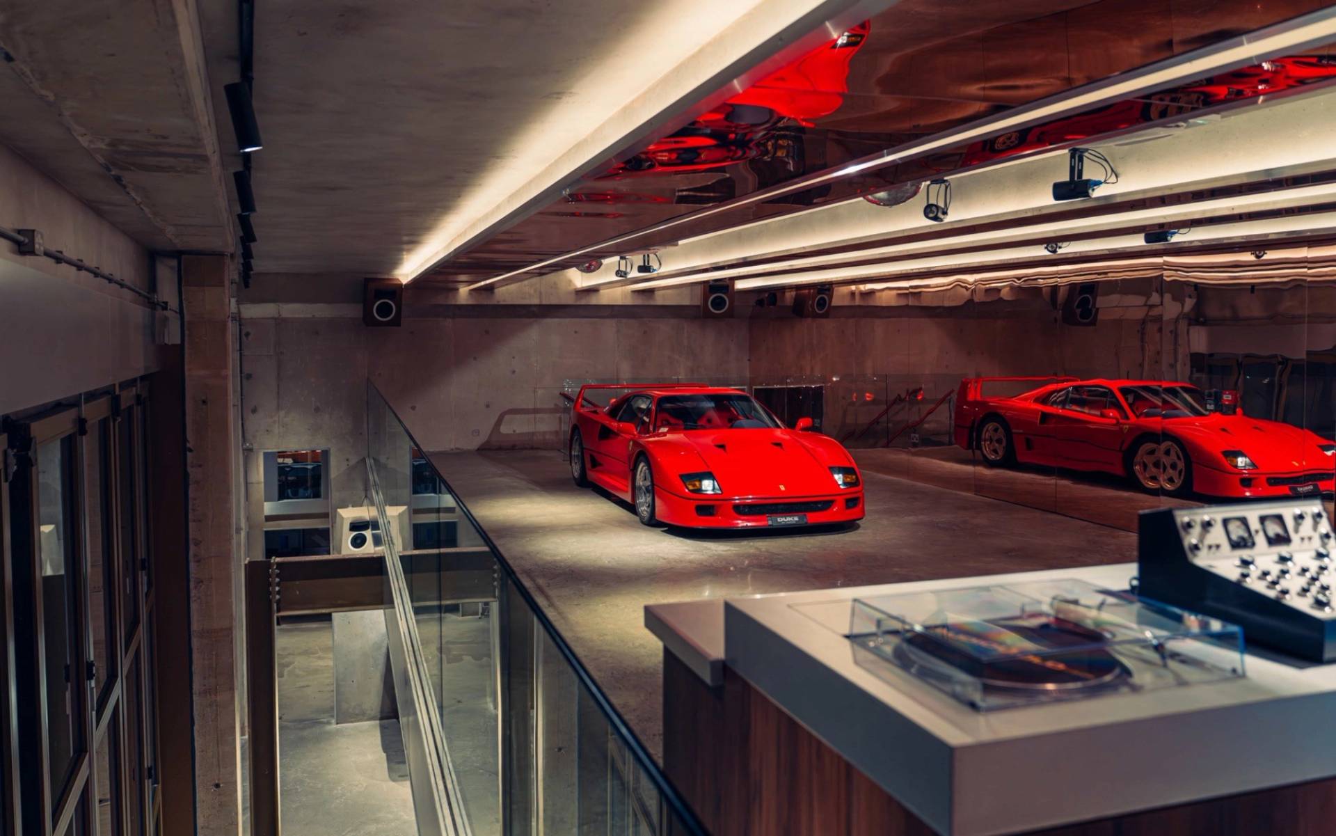 Elevated mezzanine view looking down at a red Ferrari F40 in a listening bar location house by Love Locations.