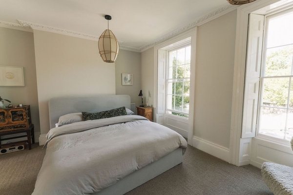 Minimalist bedroom corner featuring soft grey bedding and calm natural daylight, ideal for mattress and sleepwear brand campaigns, Love Locations.
