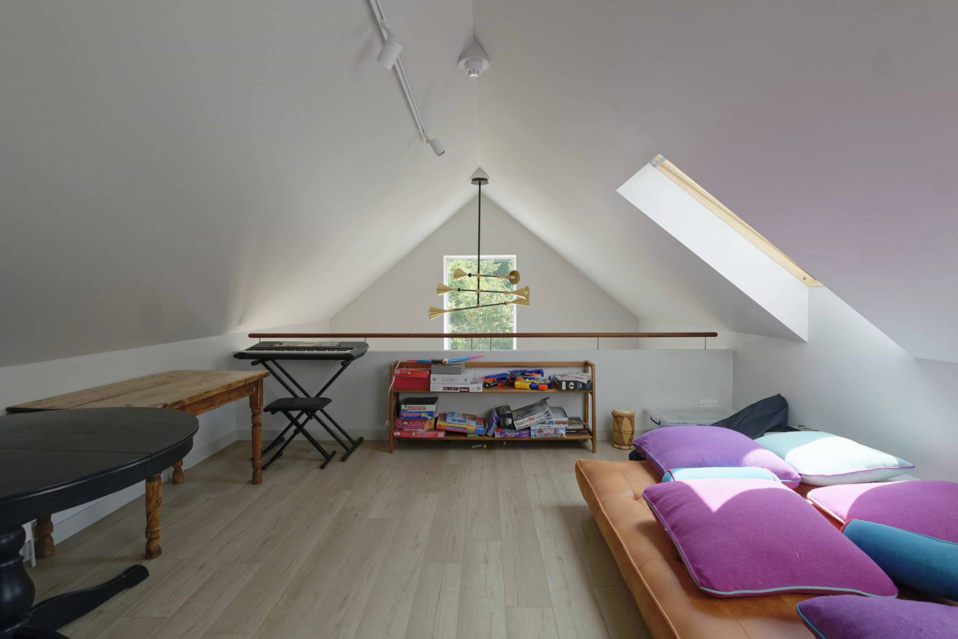 Attic workspace or studio with skylights, low wooden sofa, and light timber floorboards, Love Locations OX7.