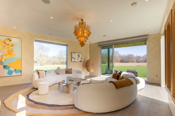 Love Locations contemporary living room shoot space Godalming Surrey GU8: Sprawling open-plan reception room with a statement curved cream sectional sofa and panoramic views, perfect for high-fashion photography.