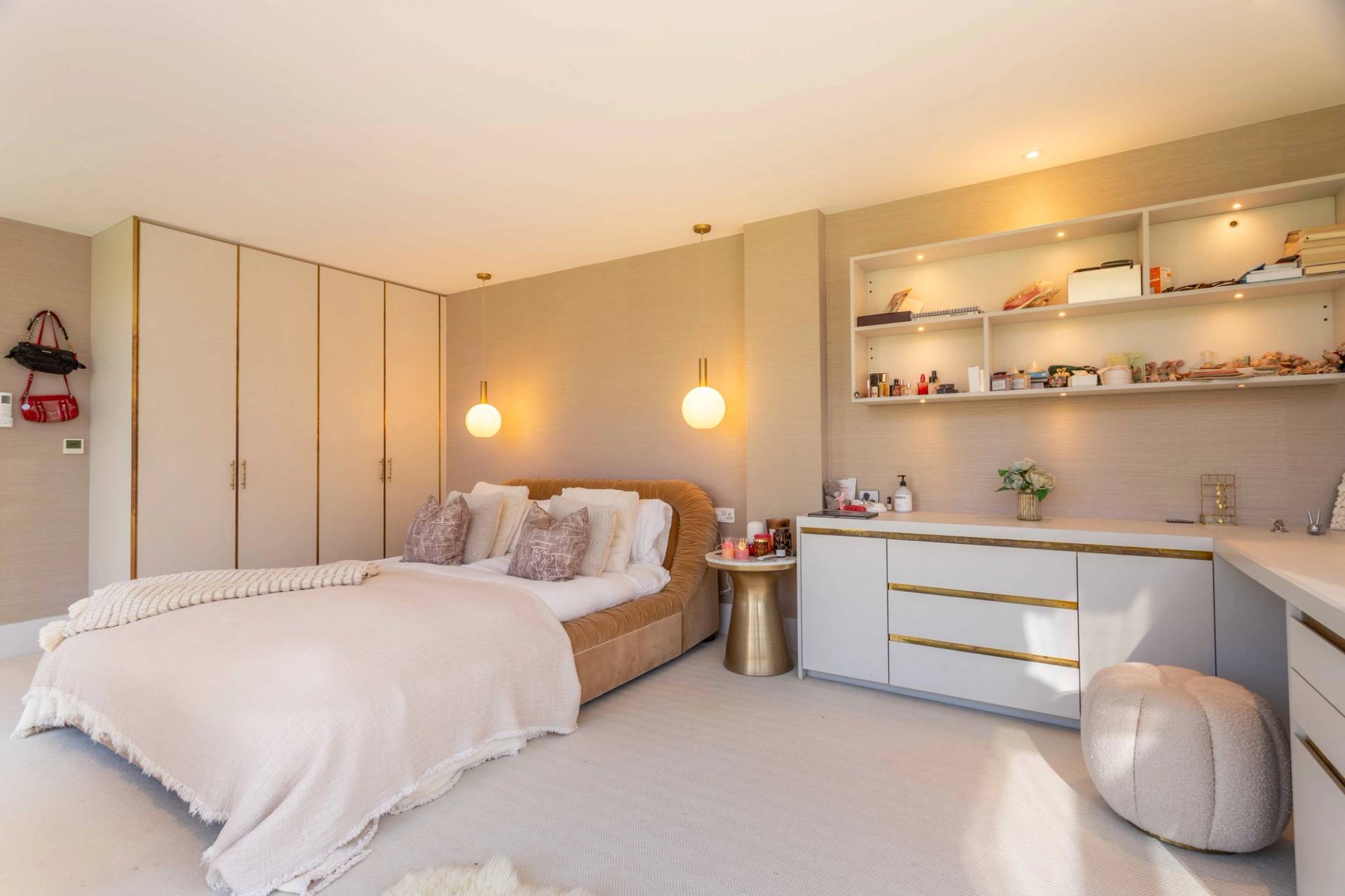 Love Locations colorful bedroom shoot space Godalming: Contemporary bedroom styled with a deep blue velvet bedframe, graphic pop art prints, and built-in neutral closets, excellent for lifestyle brand ads.