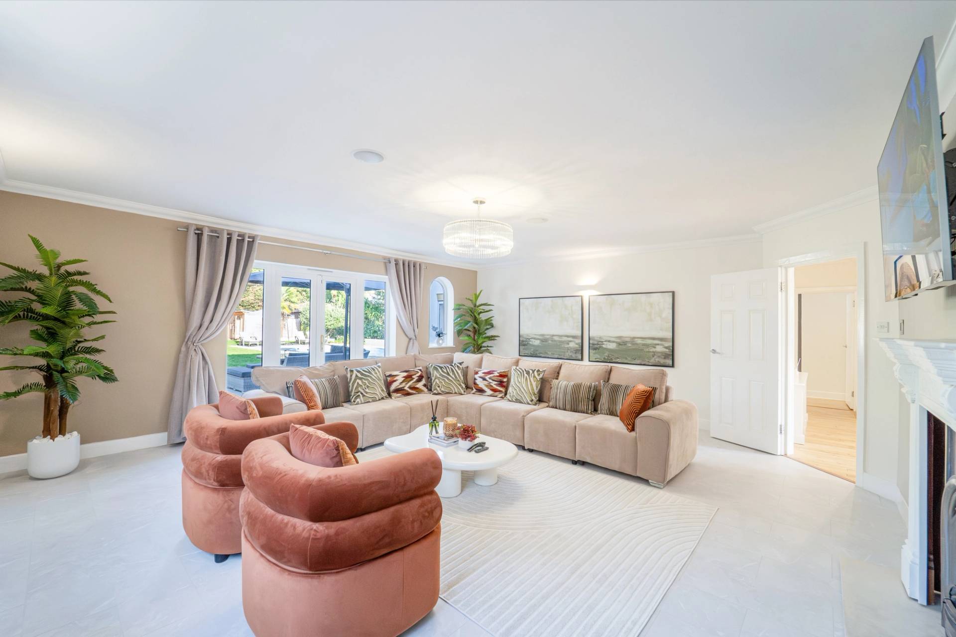 Luxury formal lounge room with terracotta velvet armchairs, large corner sofa, and chandelier, Love Locations RM11.