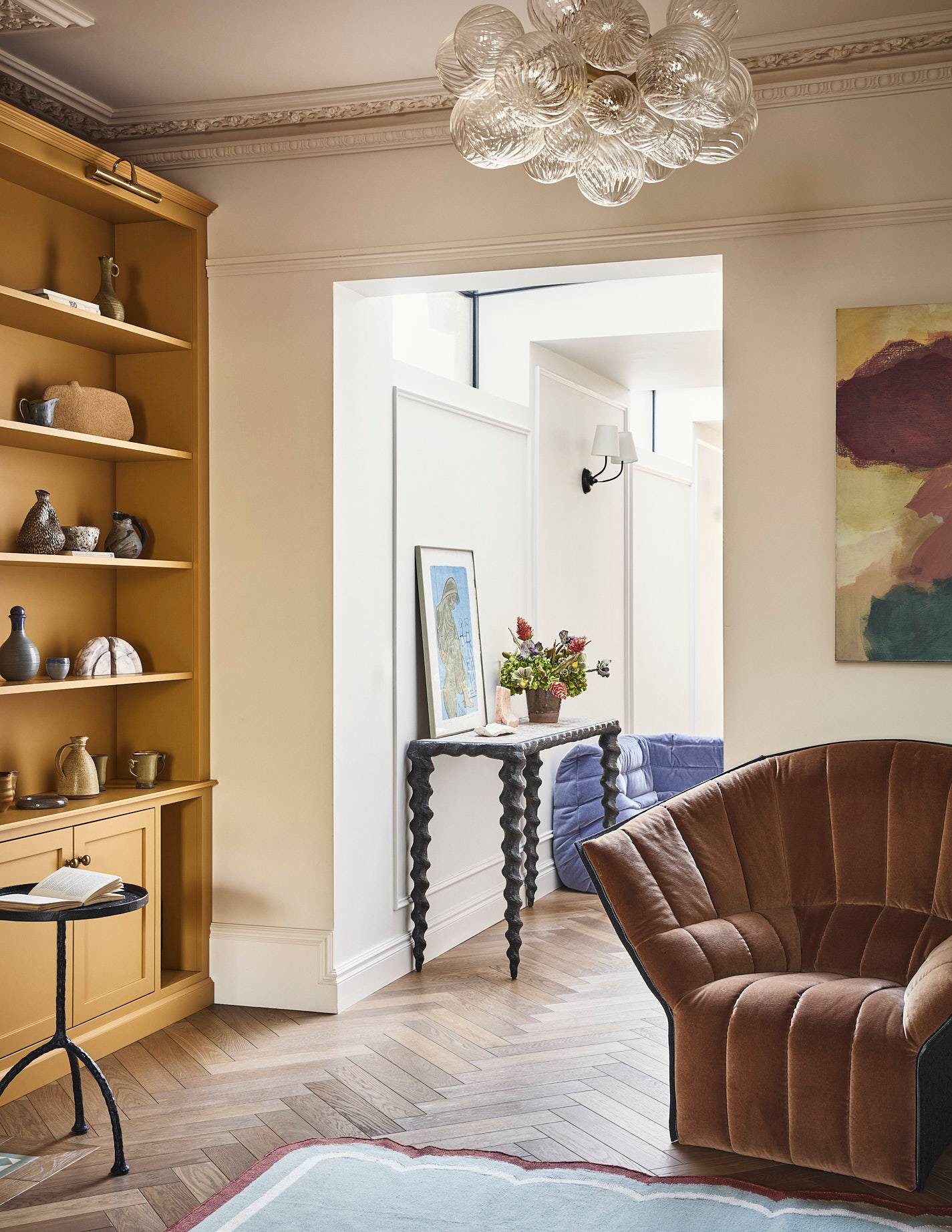 Period living room doorway transition featuring light oak built-in shelves and plush armchair seating, Love Locations SE21.