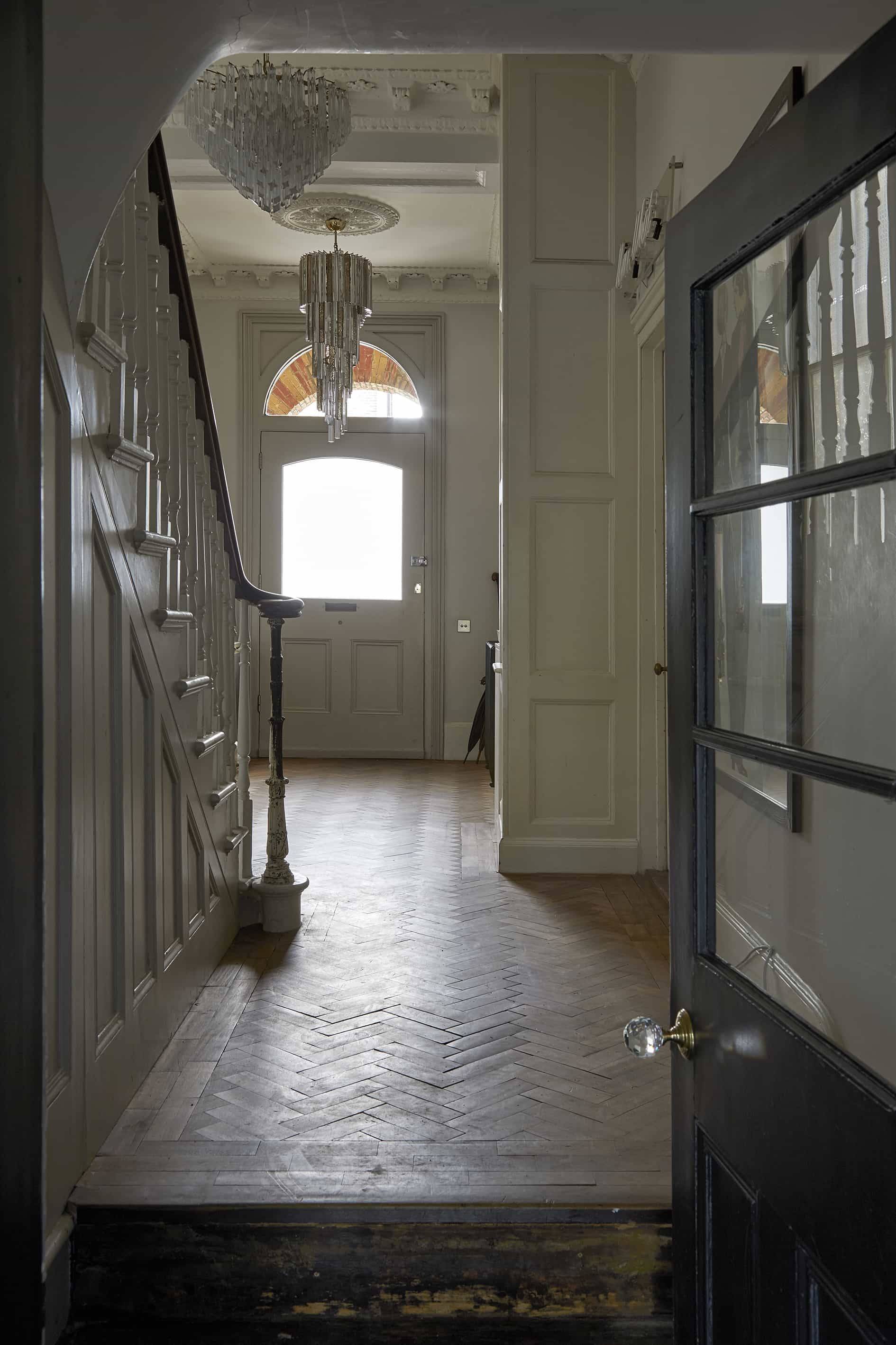 Hallway entrance looking toward the front door with parquet floor tiling and period wall panelling, Love Locations N16.