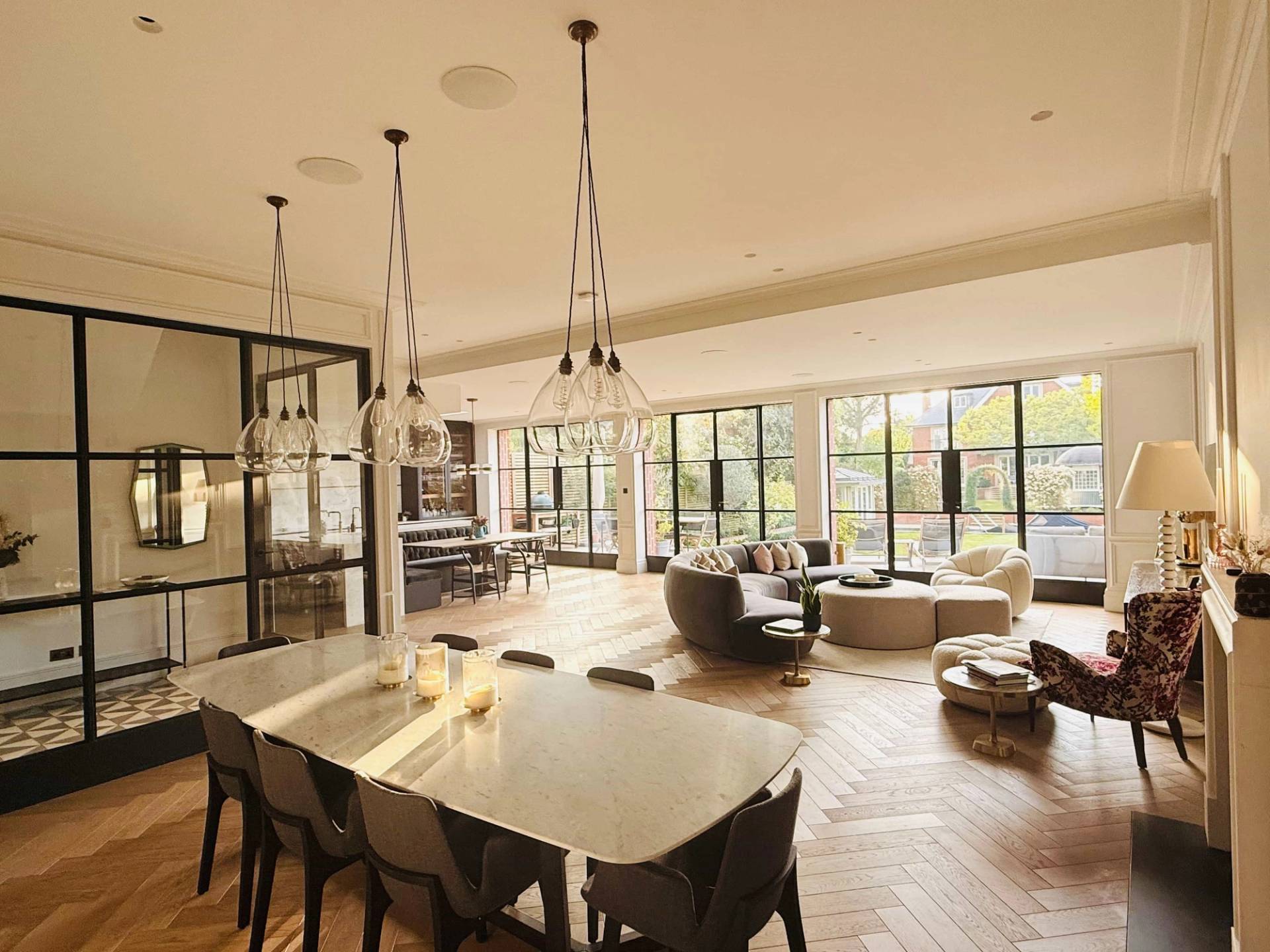 Spacious reception room with formal dining table, curved lounge seating, and floor-to-ceiling glass, Love Locations TW11.