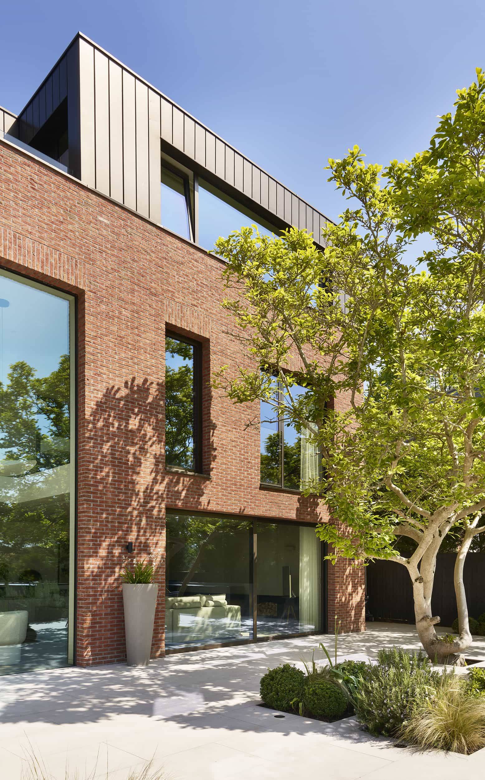 Contemporary architectural design house featuring large windows and clean brickwork lines, listed for media hire by Love Locations.