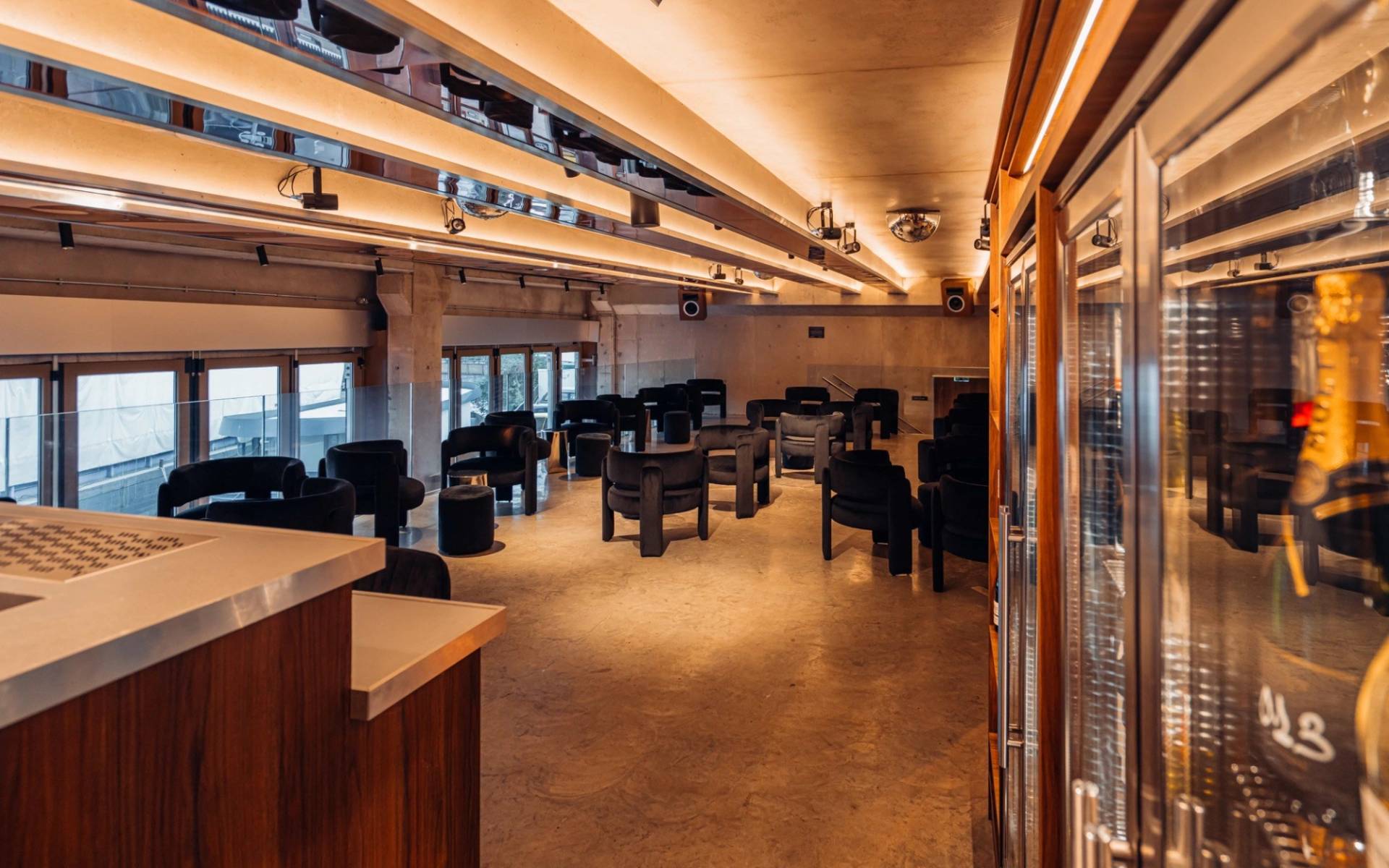 Open lounge space and drinks display fridge in a modern audio bar filming venue through Love Locations.