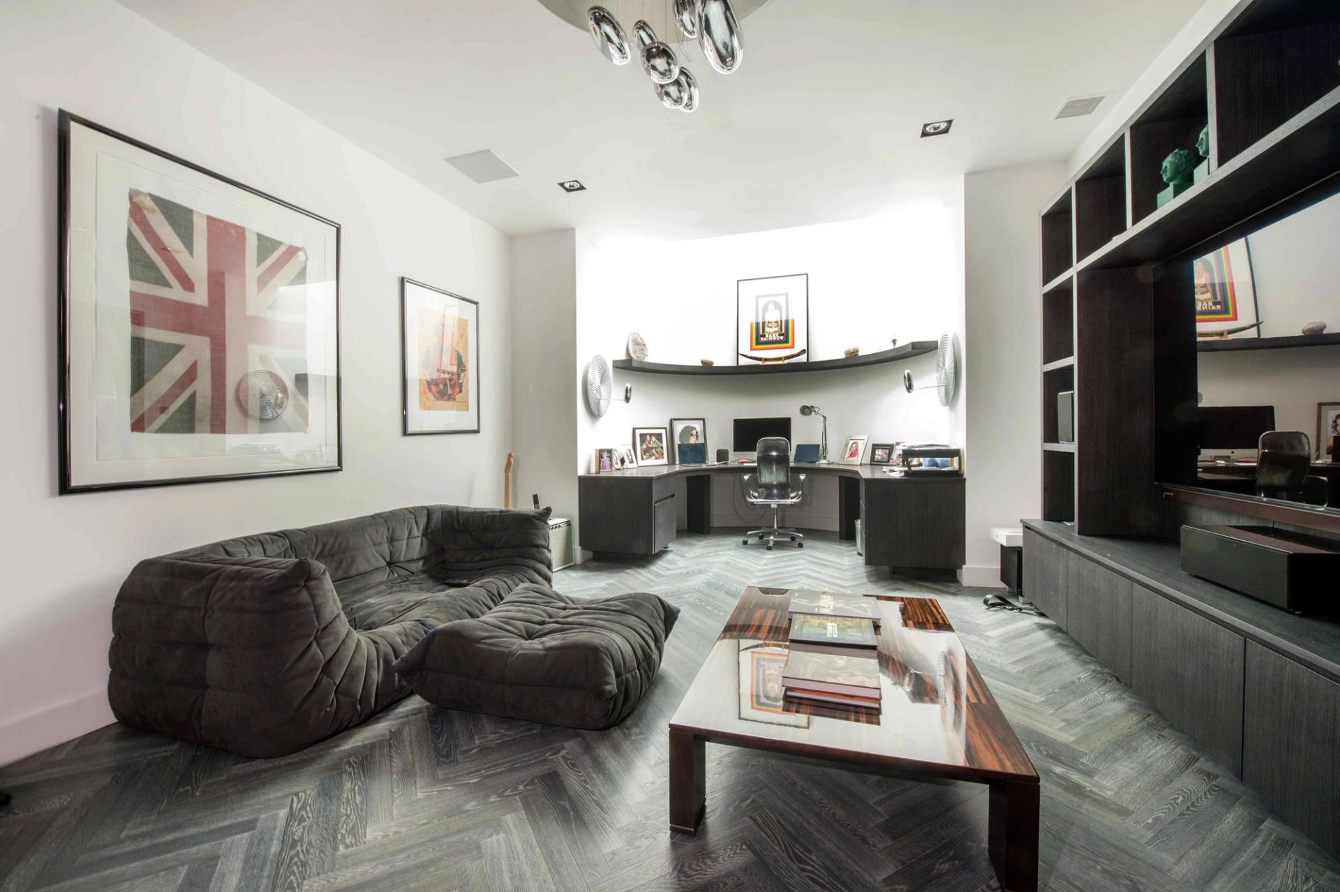Luxury home office study space featuring a minimalist desk setup, dark wood cabinetry, and a cozy lounge area, Love Locations.